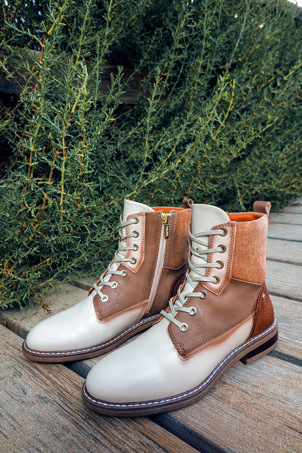 Image of some Pikolinos boots in ivory and brandy colors in a natural environment.